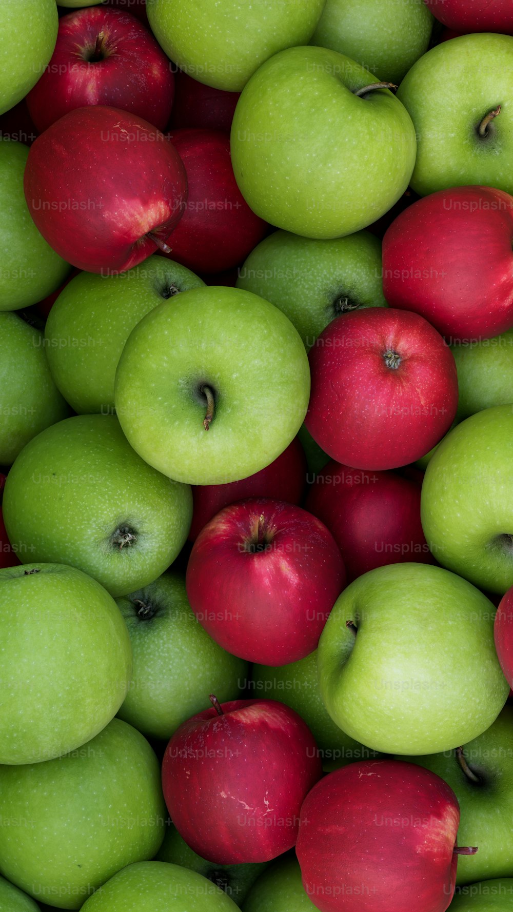 a pile of green and red apples sitting next to each other
