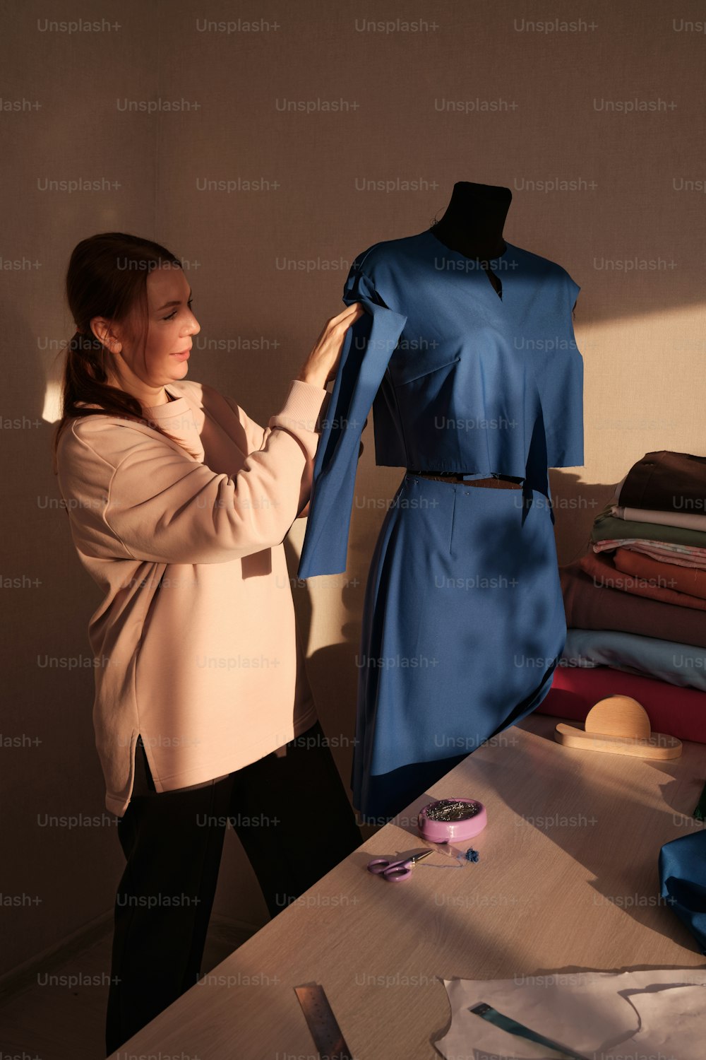 a woman standing in front of a dress on a mannequin