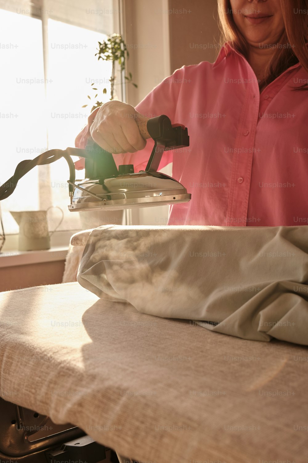 a woman ironing clothes on an ironing board