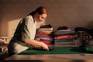 a woman cutting fabric with a pair of scissors