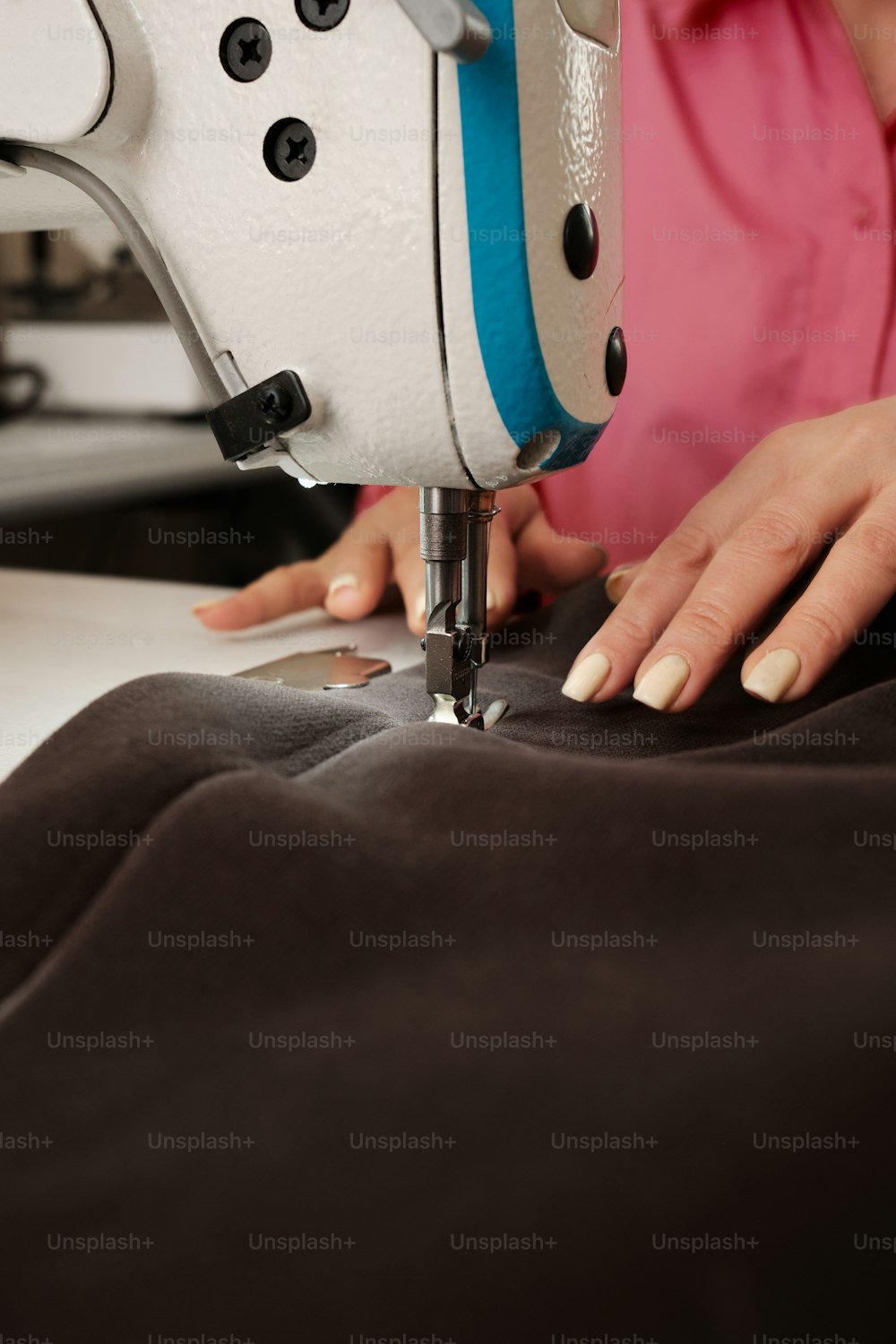 uma mulher que usa uma máquina de costura em um pedaço de tecido