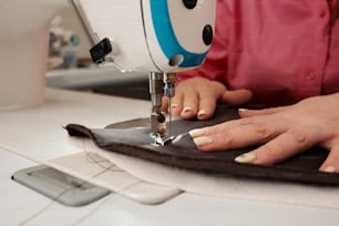 a woman using a sewing machine on a piece of fabric