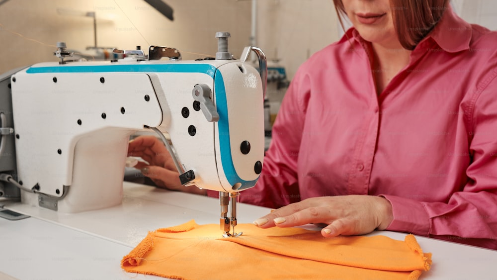 uma mulher está trabalhando em uma máquina de costura