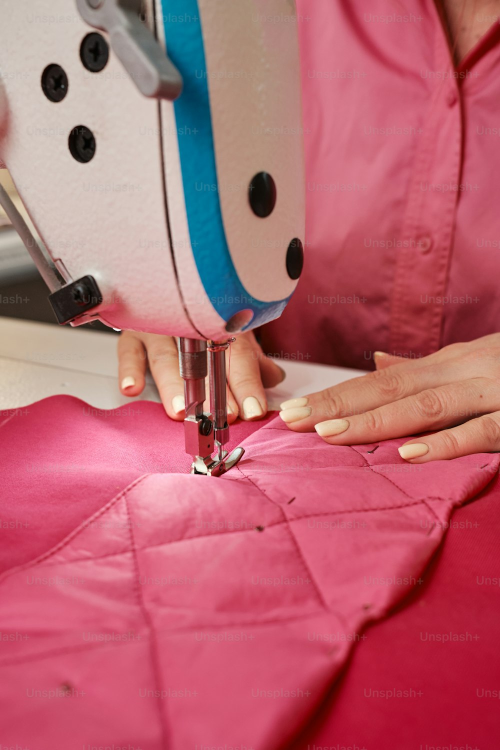 a woman using a sewing machine to sew a quilt