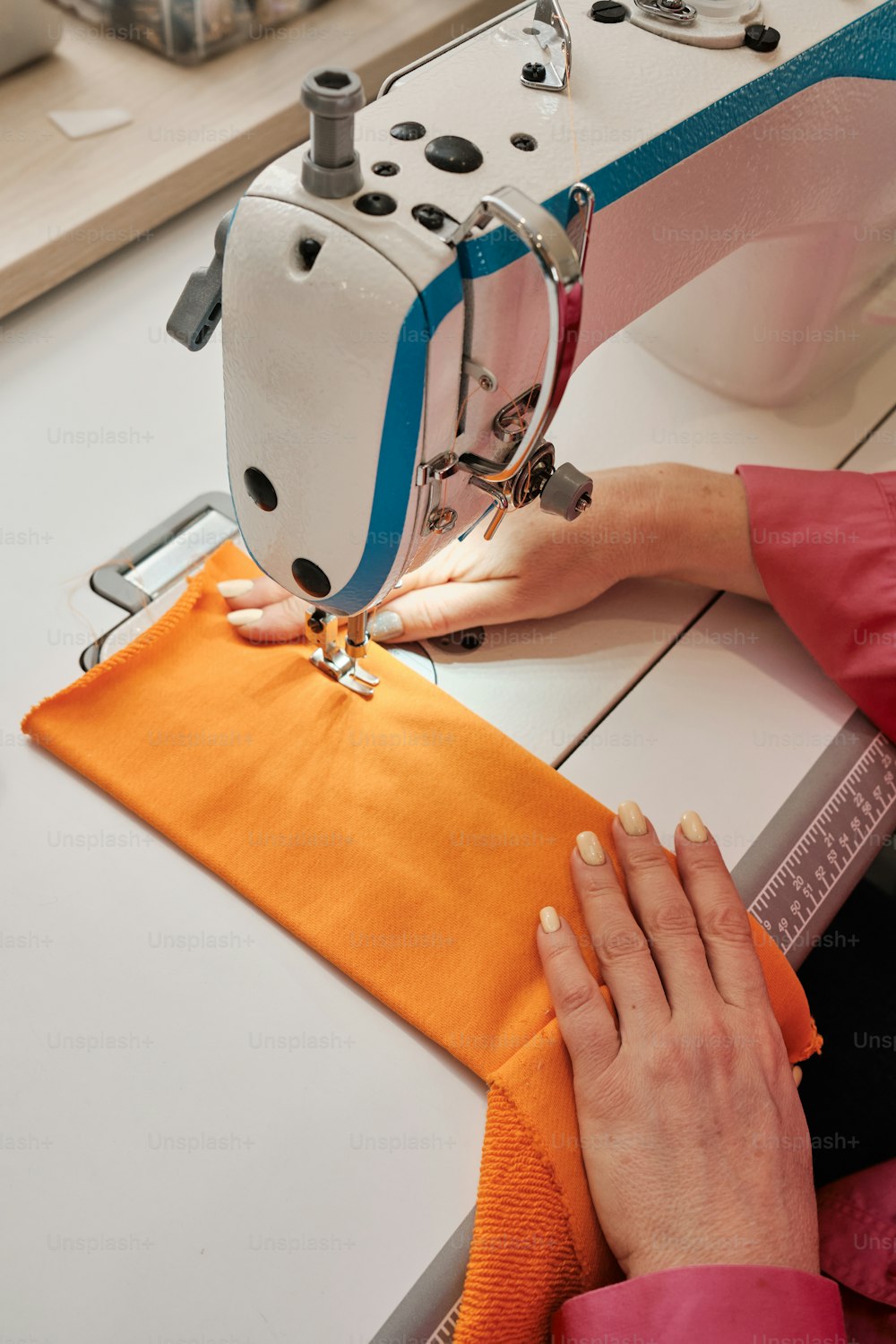 a woman using a sewing machine to sew a piece of fabric