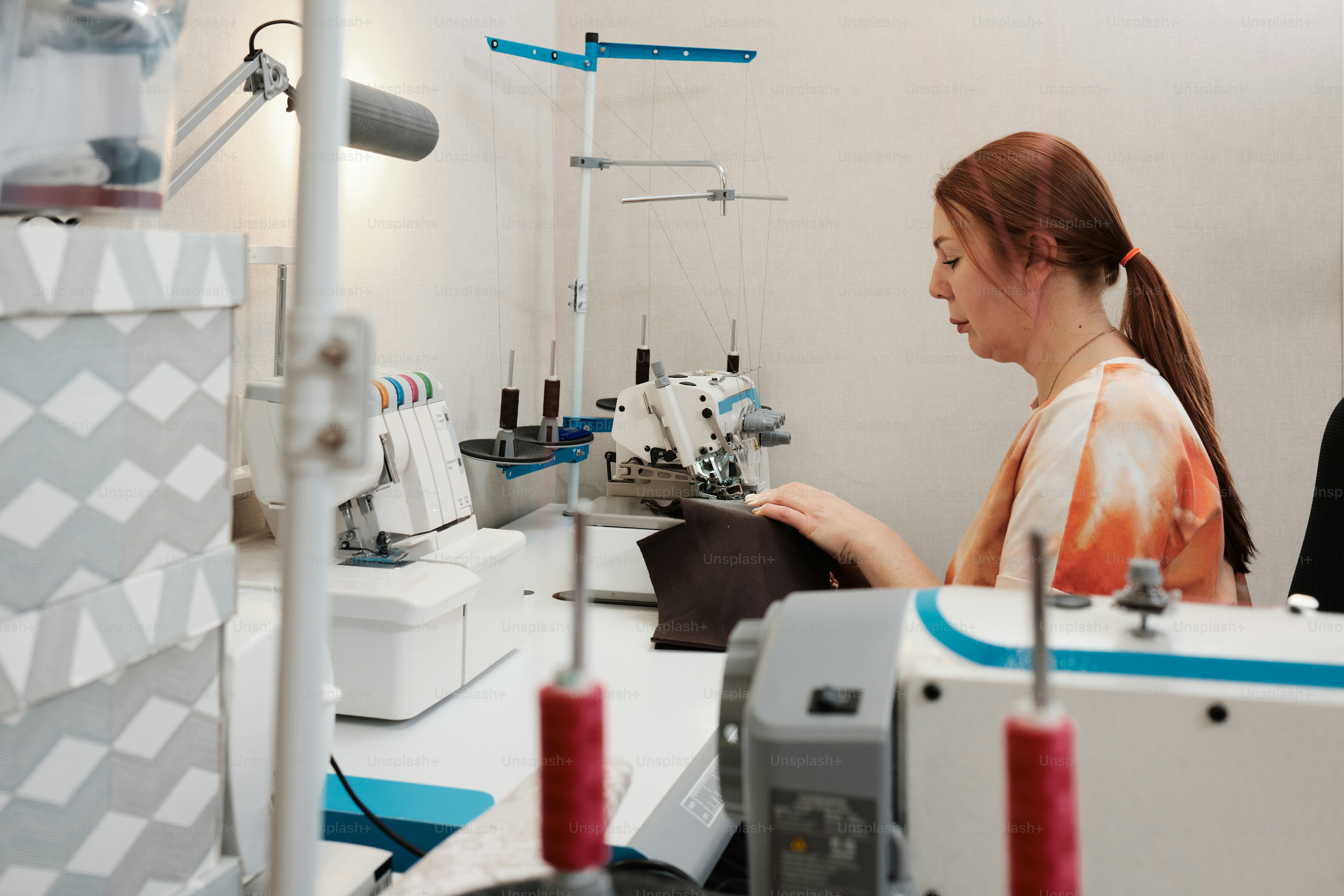 Una mujer está trabajando en una máquina de coser