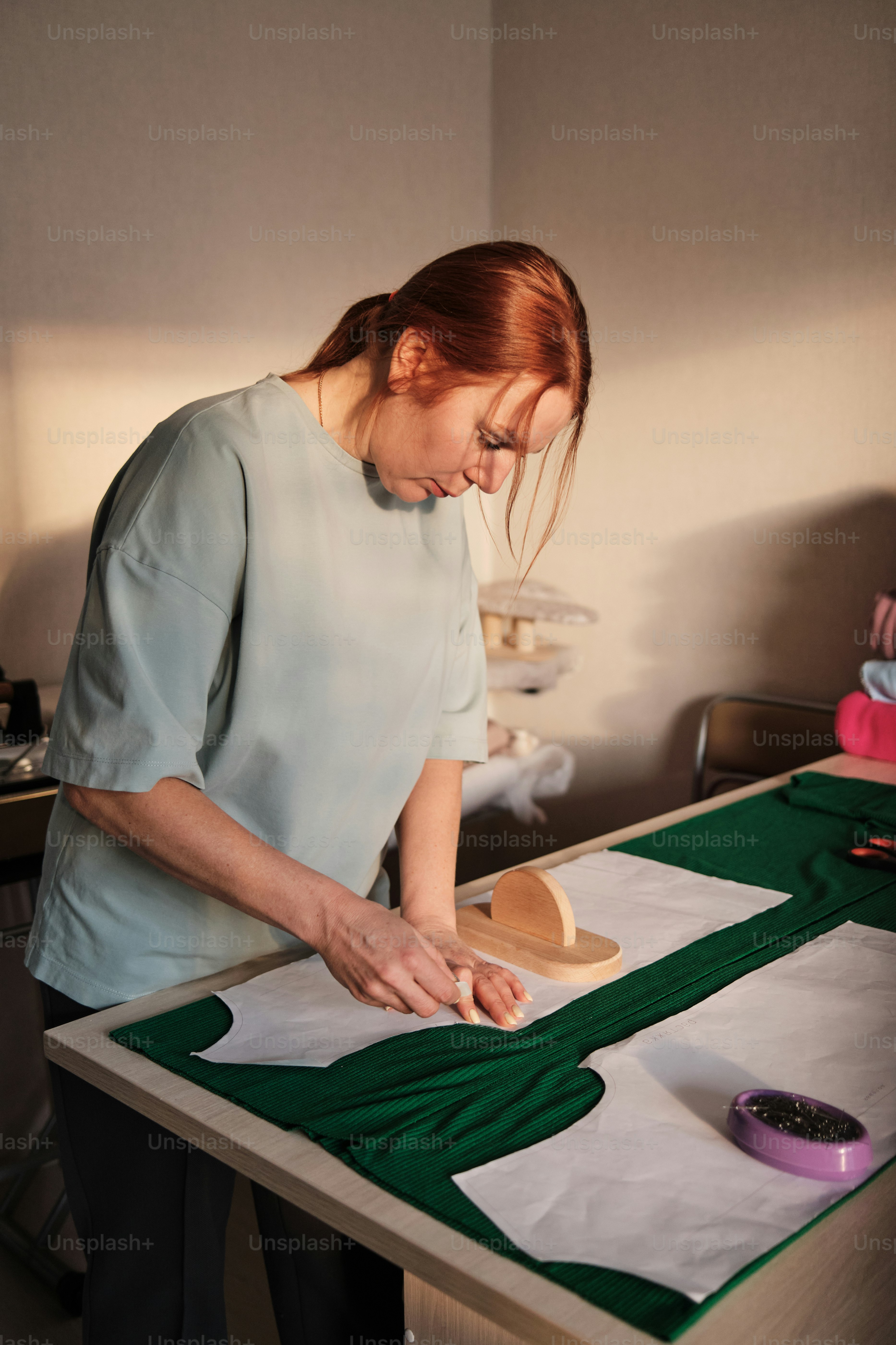 una donna in piedi sopra un tavolo che taglia un pezzo di carta