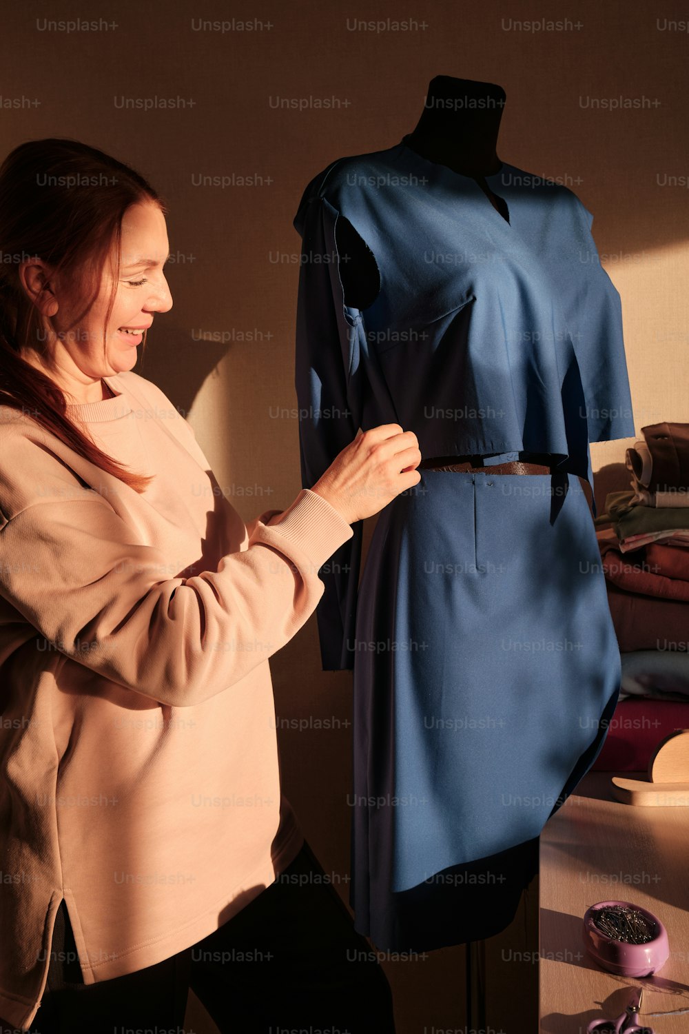a woman standing next to a dress on a mannequin