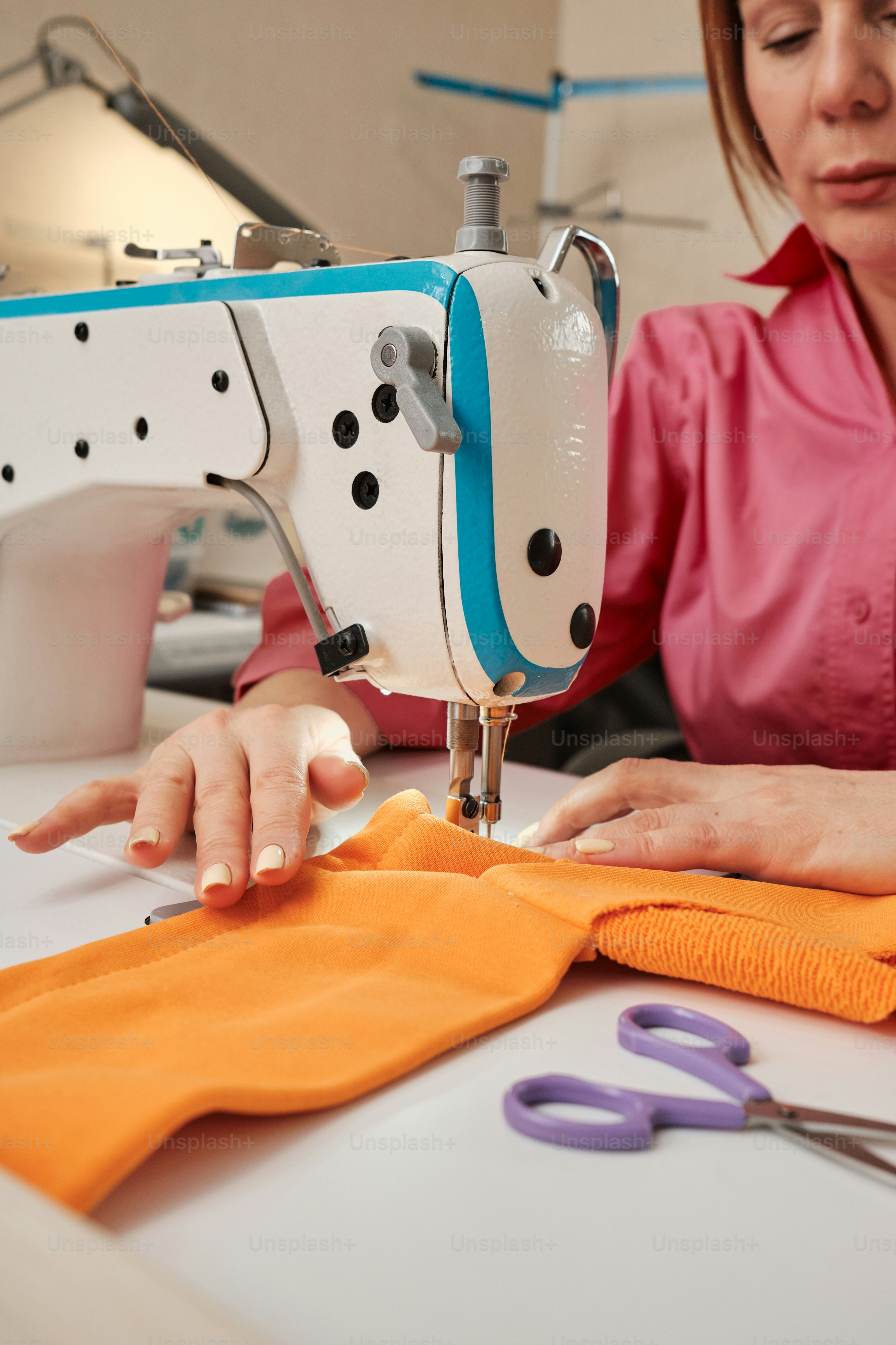 Una mujer está trabajando en una máquina de coser