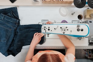 uma mulher está costurando em uma máquina de costura
