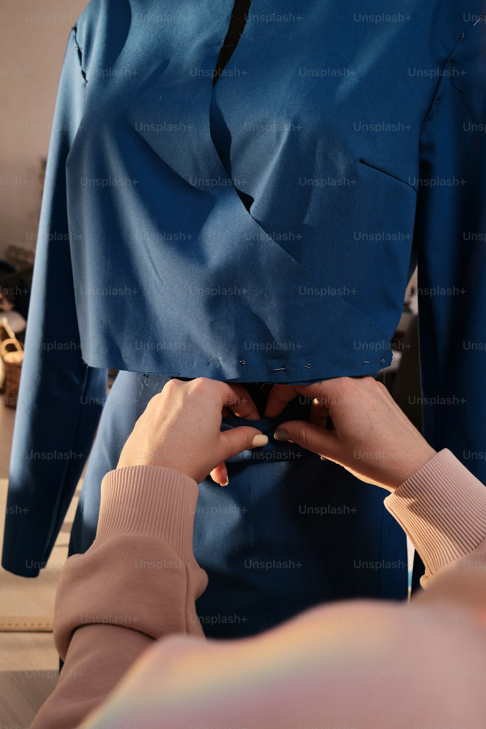 a woman is working on a blue shirt