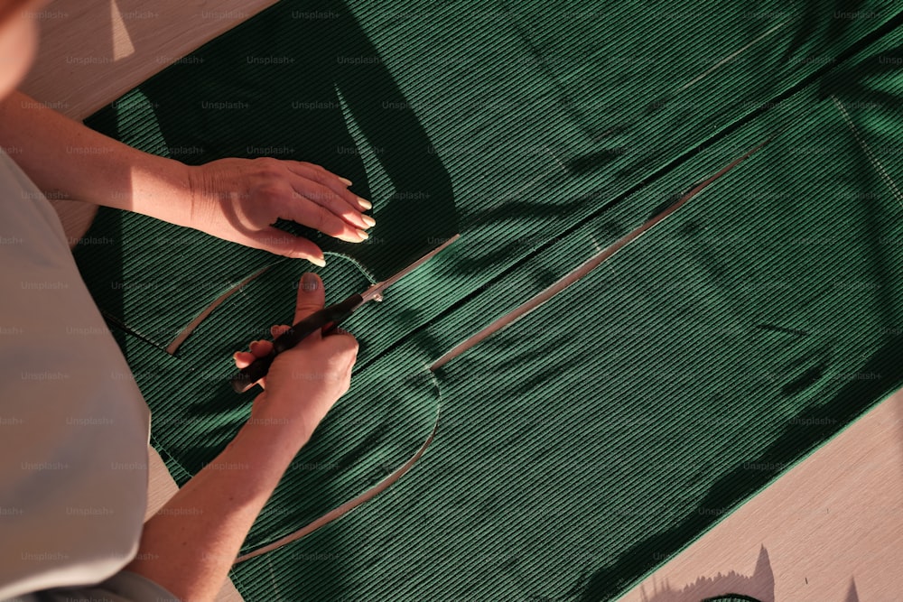 a person cutting fabric with a pair of scissors