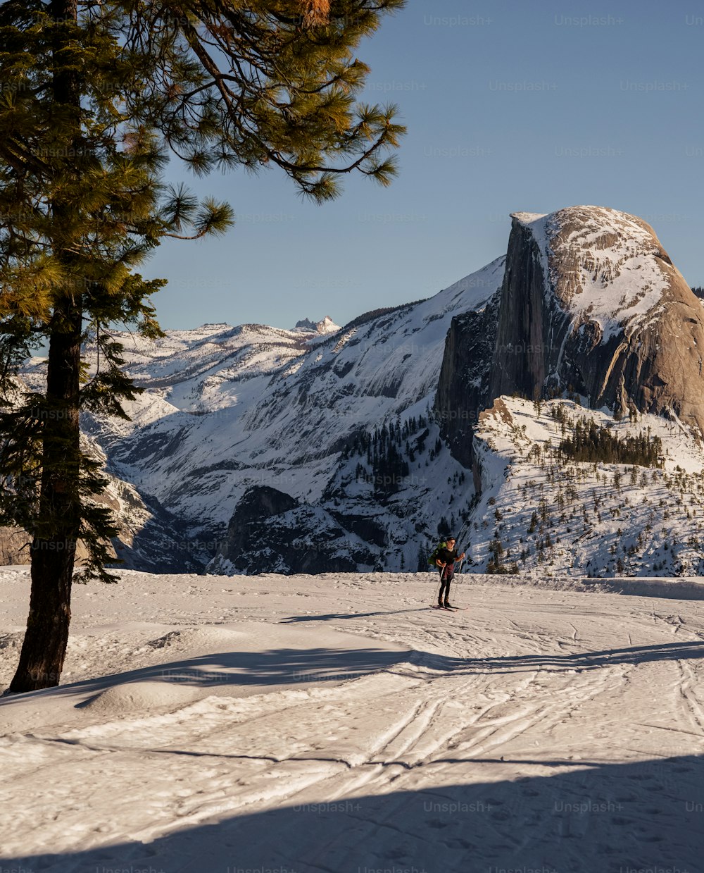 una persona in piedi nella neve vicino a una montagna