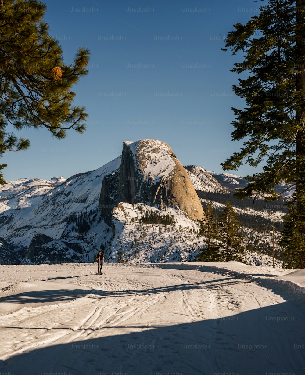 uma pessoa em pé em cima de uma encosta coberta de neve