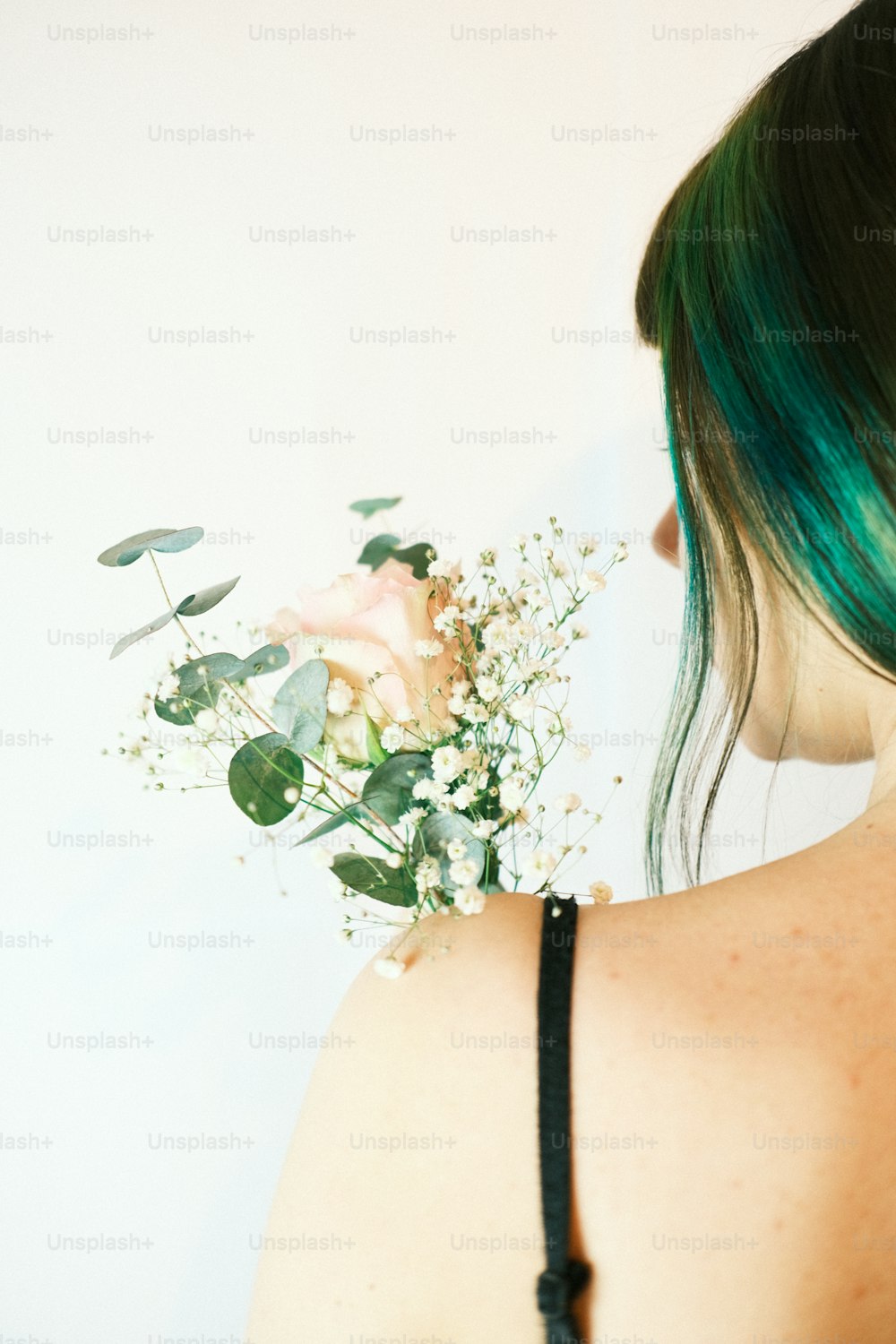 a woman with green hair is holding a bouquet of flowers