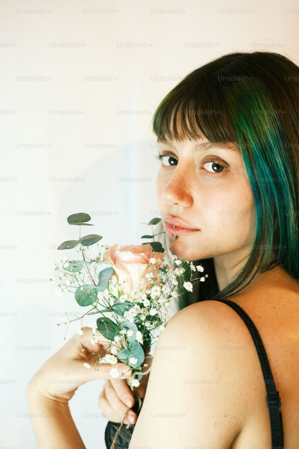 uma mulher com cabelo verde segurando um buquê de flores