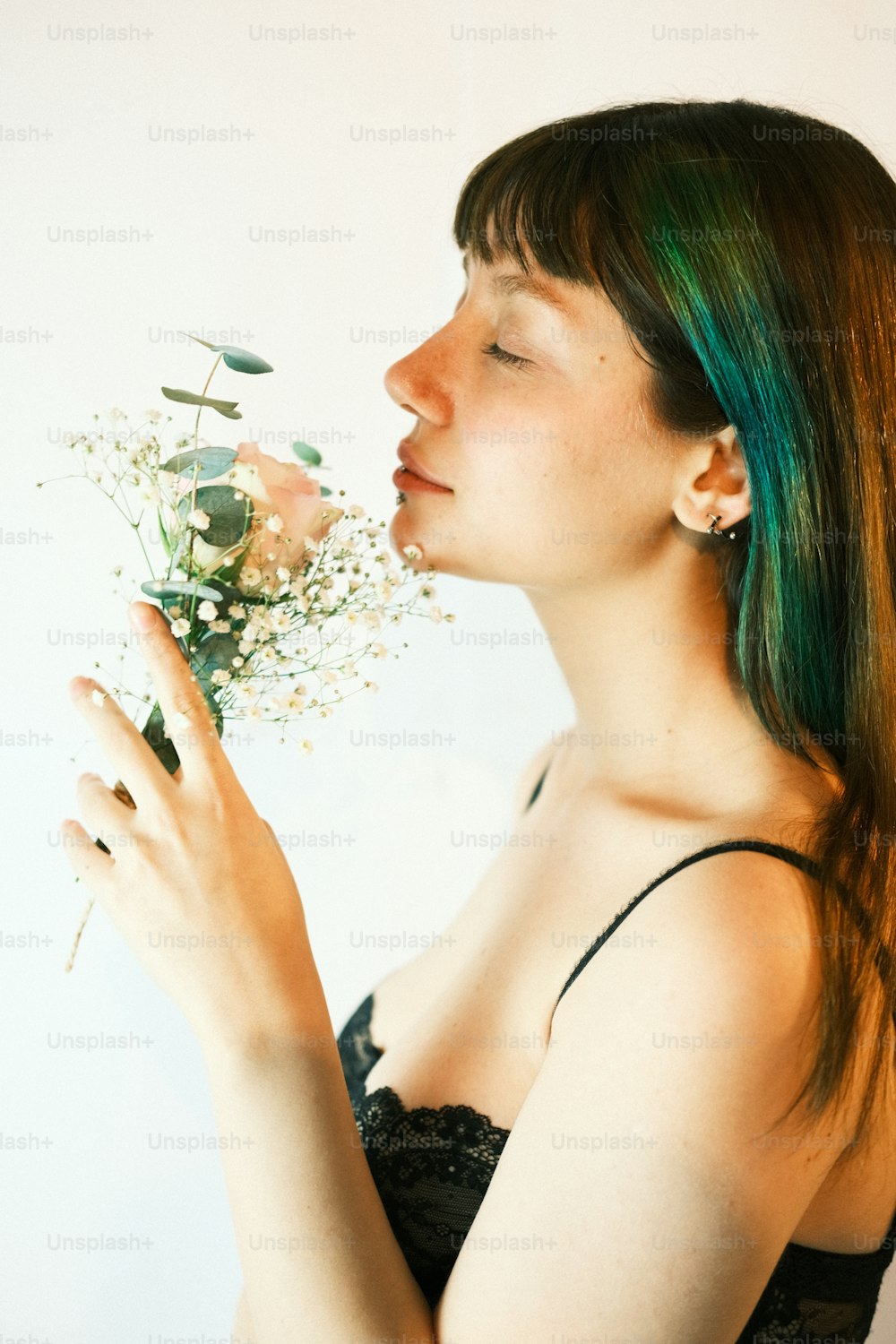 Una donna con i capelli verdi che tiene un fiore