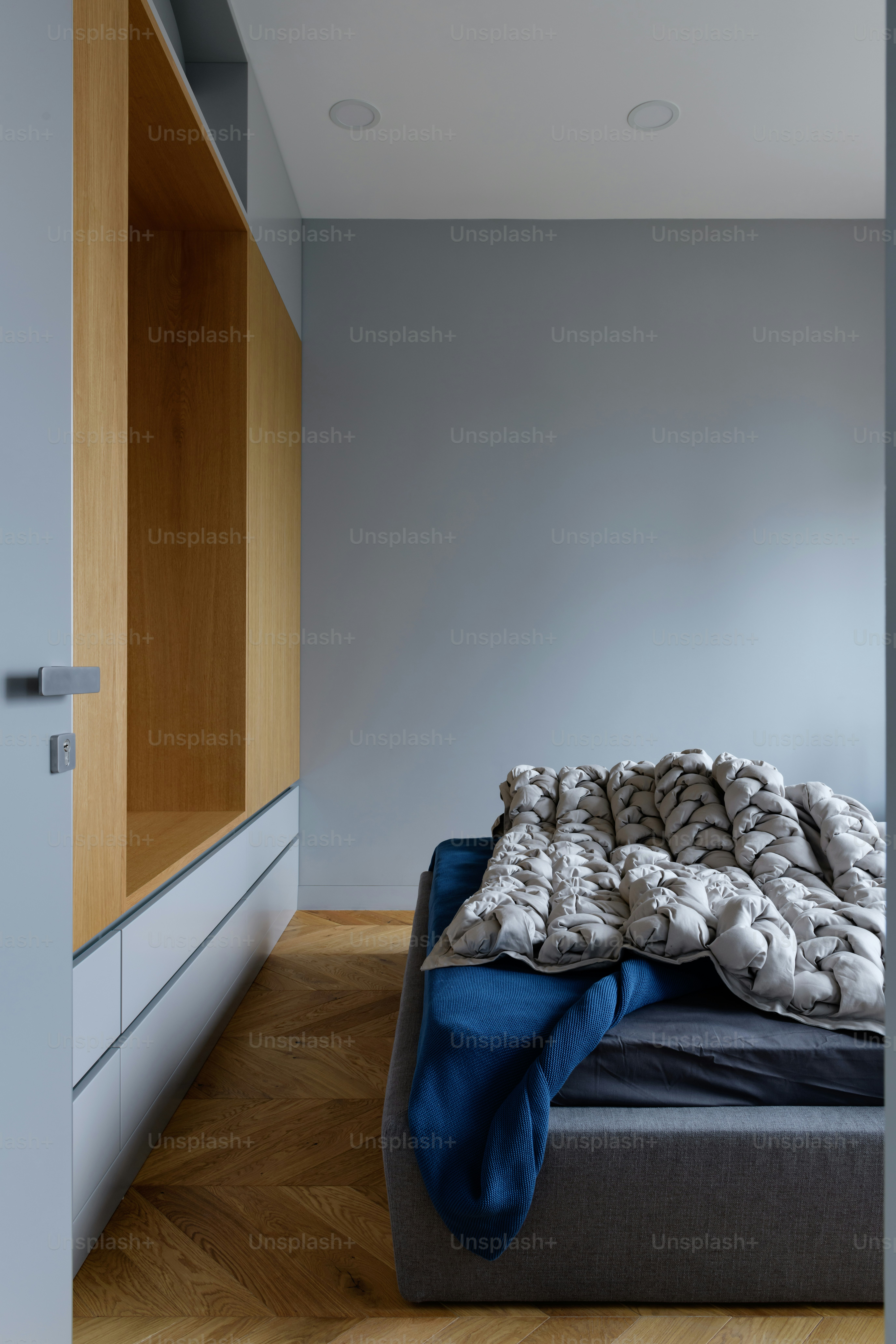tempat tidur yang duduk di kamar tidur di sebelah lantai kayu