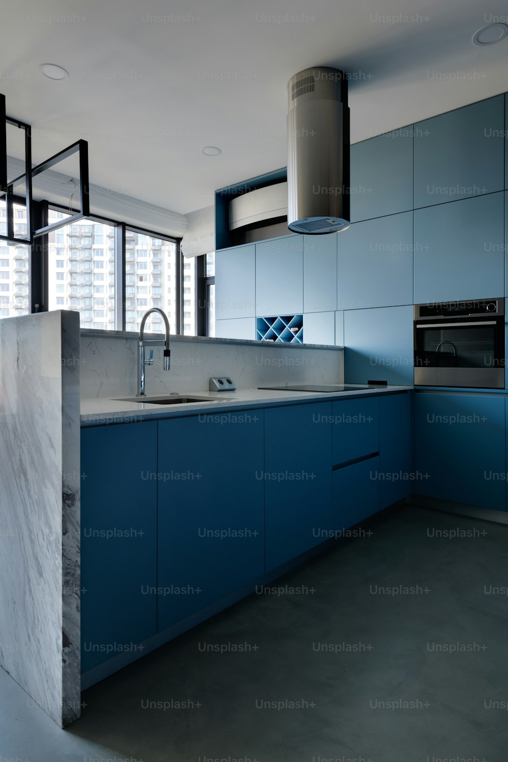 una cocina con gabinetes azules y una encimera de mármol