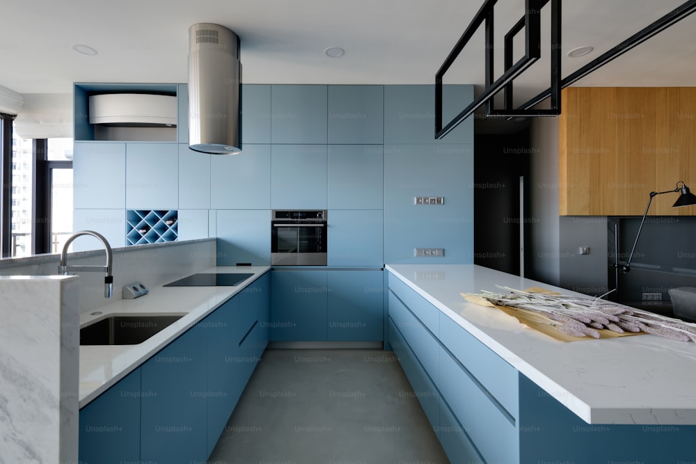 a kitchen with blue cabinets and a white counter top