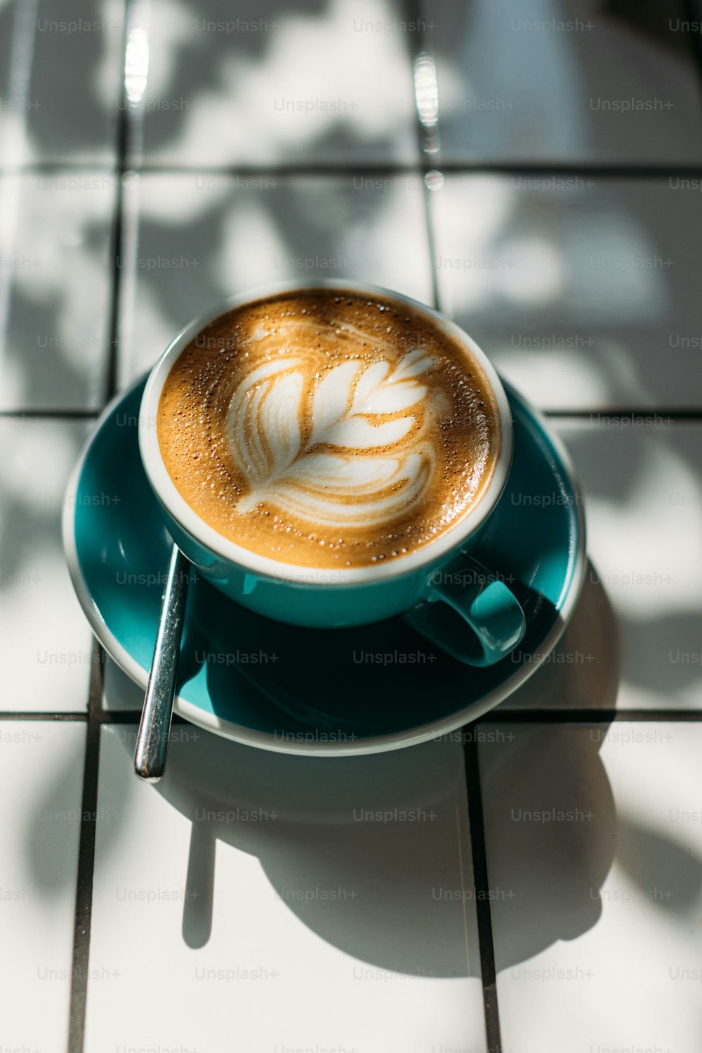 Ein Cappuccino auf einer Untertasse auf einem Fliesenboden