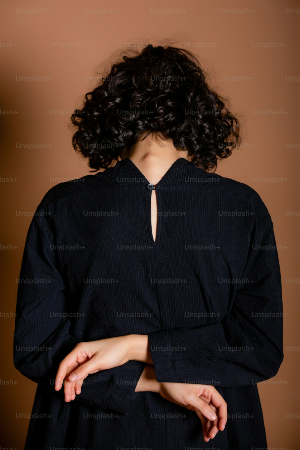 Eine Frau mit lockigem Haar in einem schwarzen Kleid