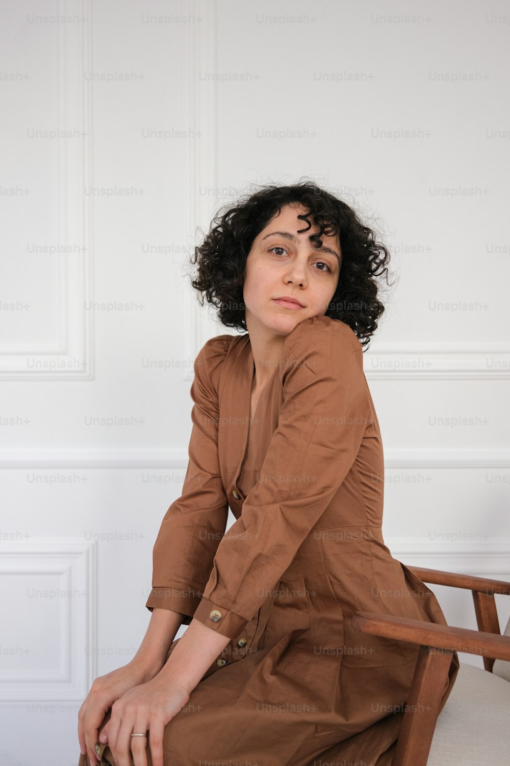 a woman sitting on top of a wooden chair