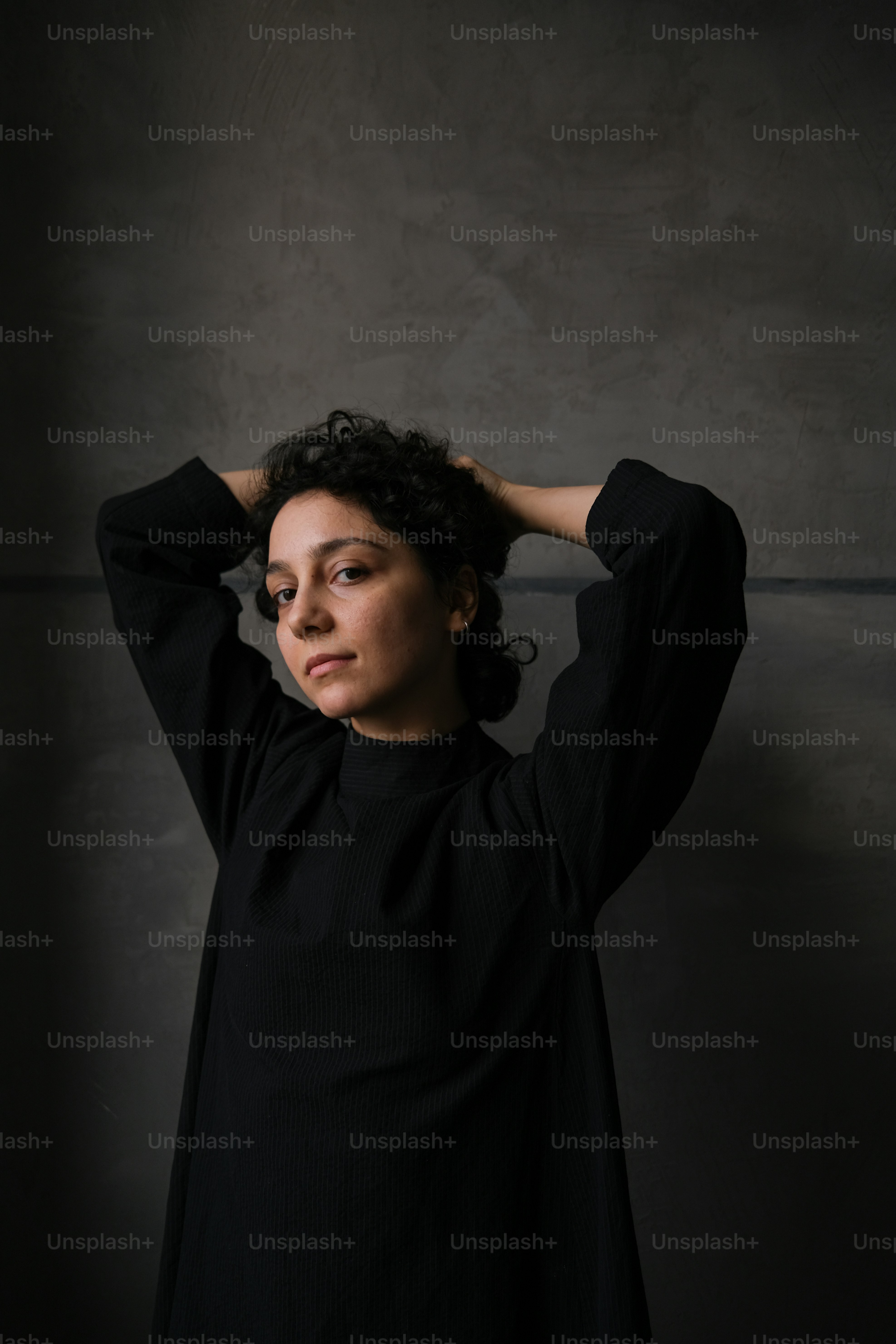 Una donna è in posa per una foto con le mani sulla testa