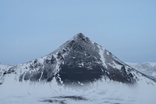 uma montanha coberta de neve com um céu azul no fundo