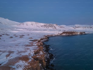 a large body of water surrounded by snow covered mountains