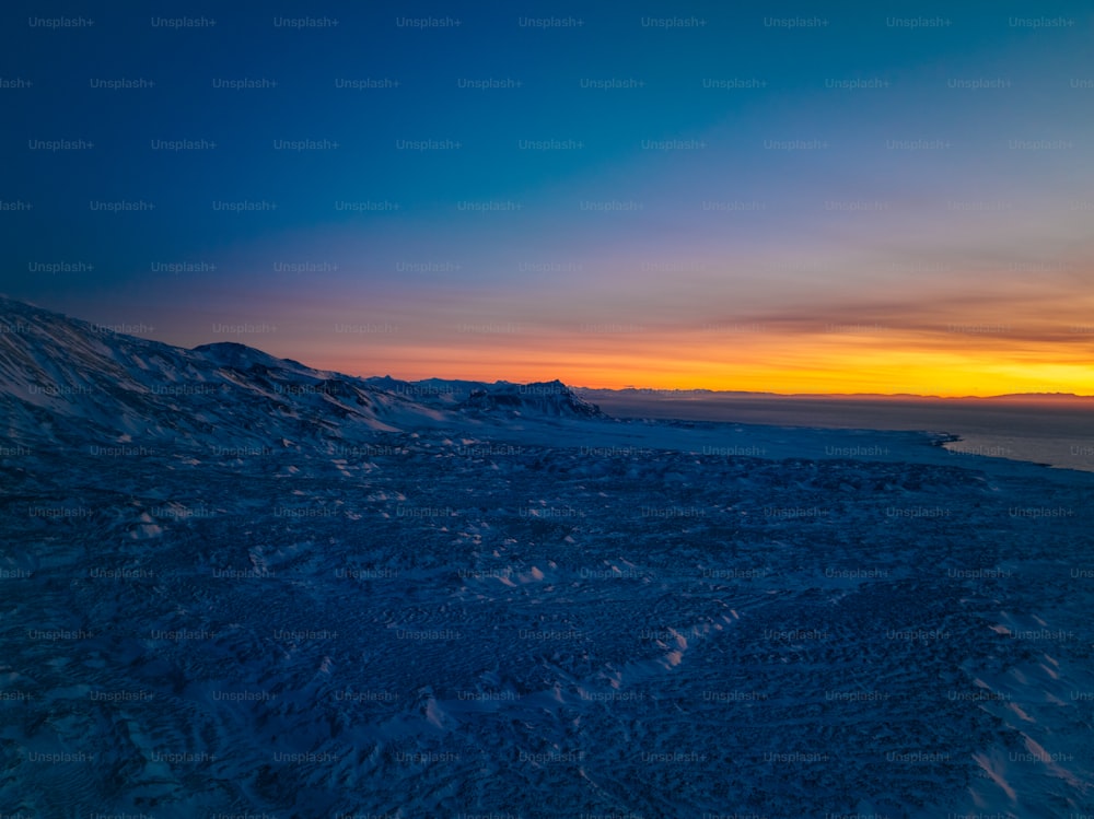 Le soleil se couche sur une montagne enneigée
