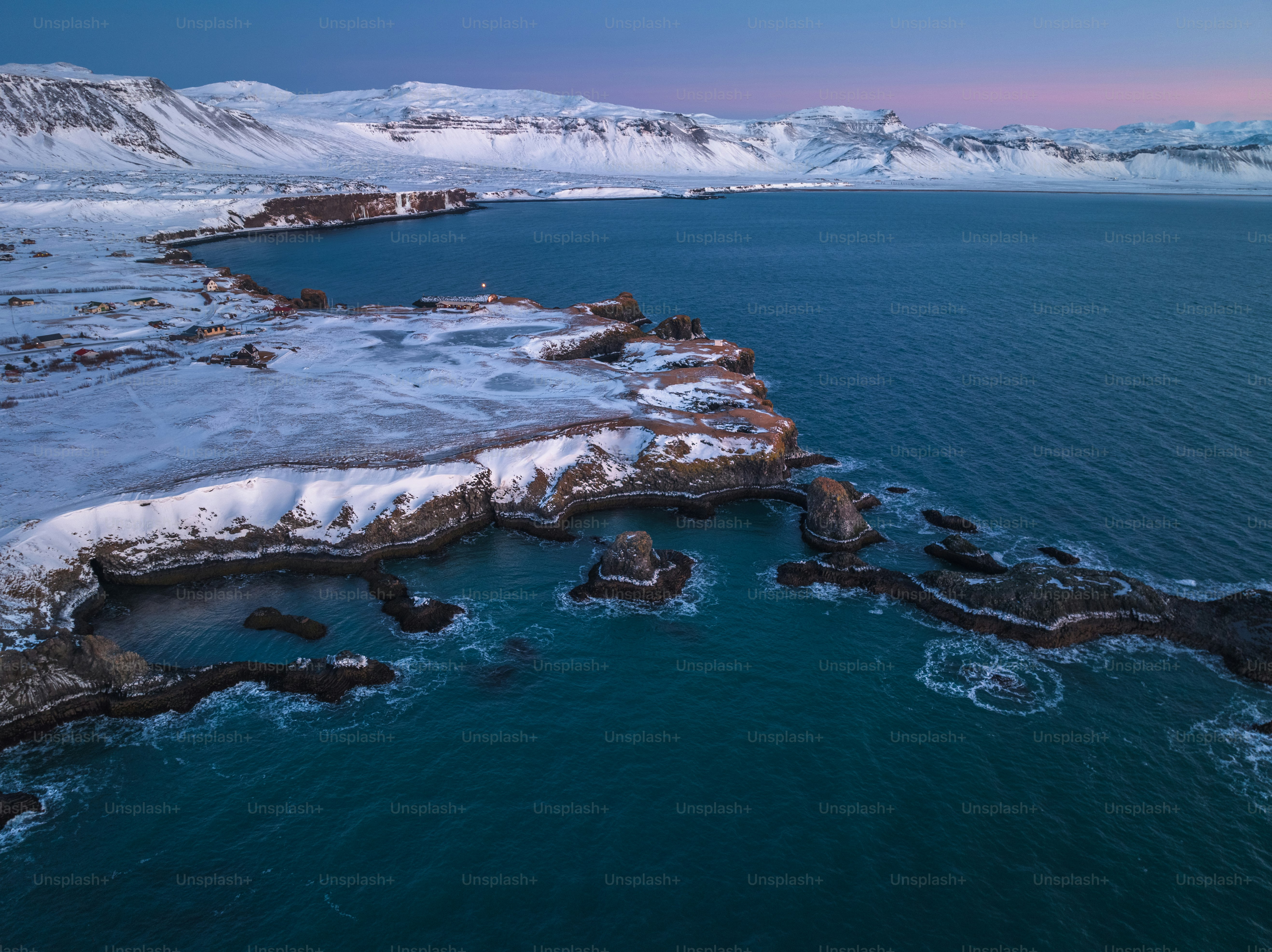a large body of water surrounded by snow covered mountains