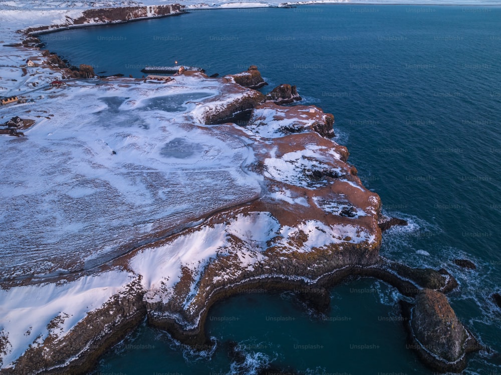 a large body of water surrounded by snow covered land