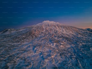 a large snow covered mountain under a blue sky