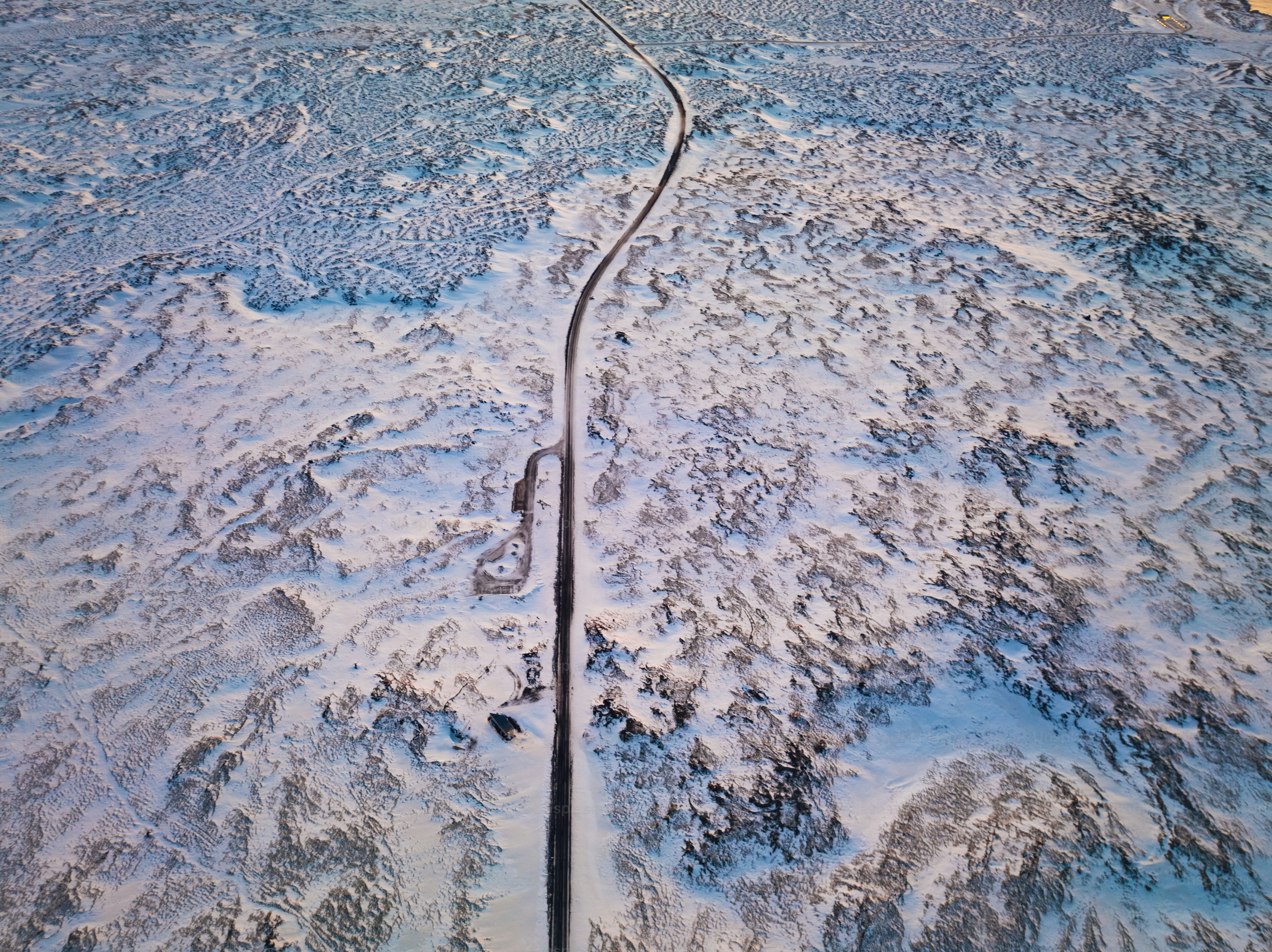 an aerial view of a road in the snow