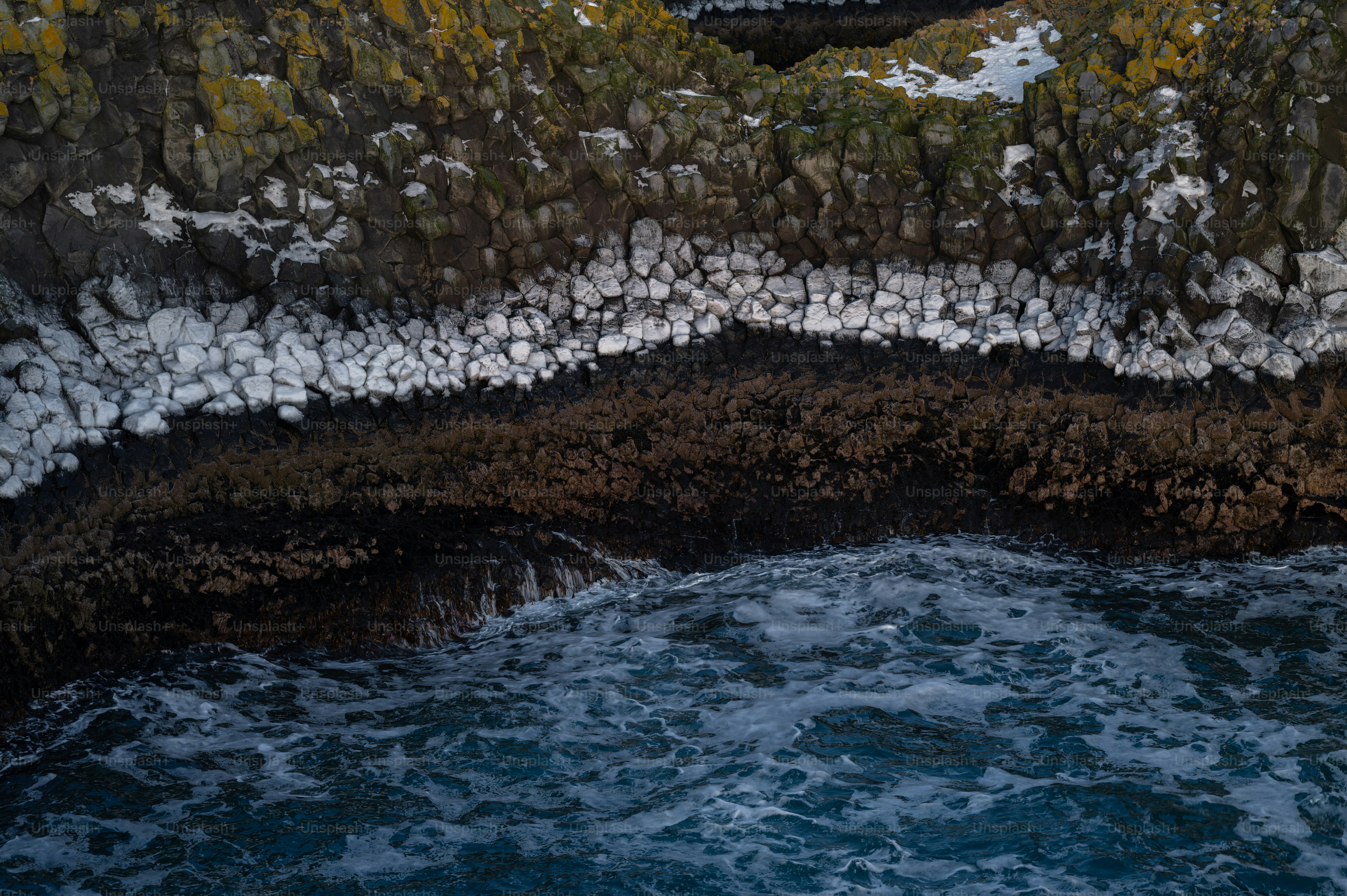 a large body of water next to a rocky cliff