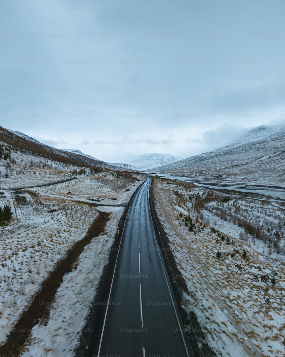 uma estrada no meio de uma paisagem nevada