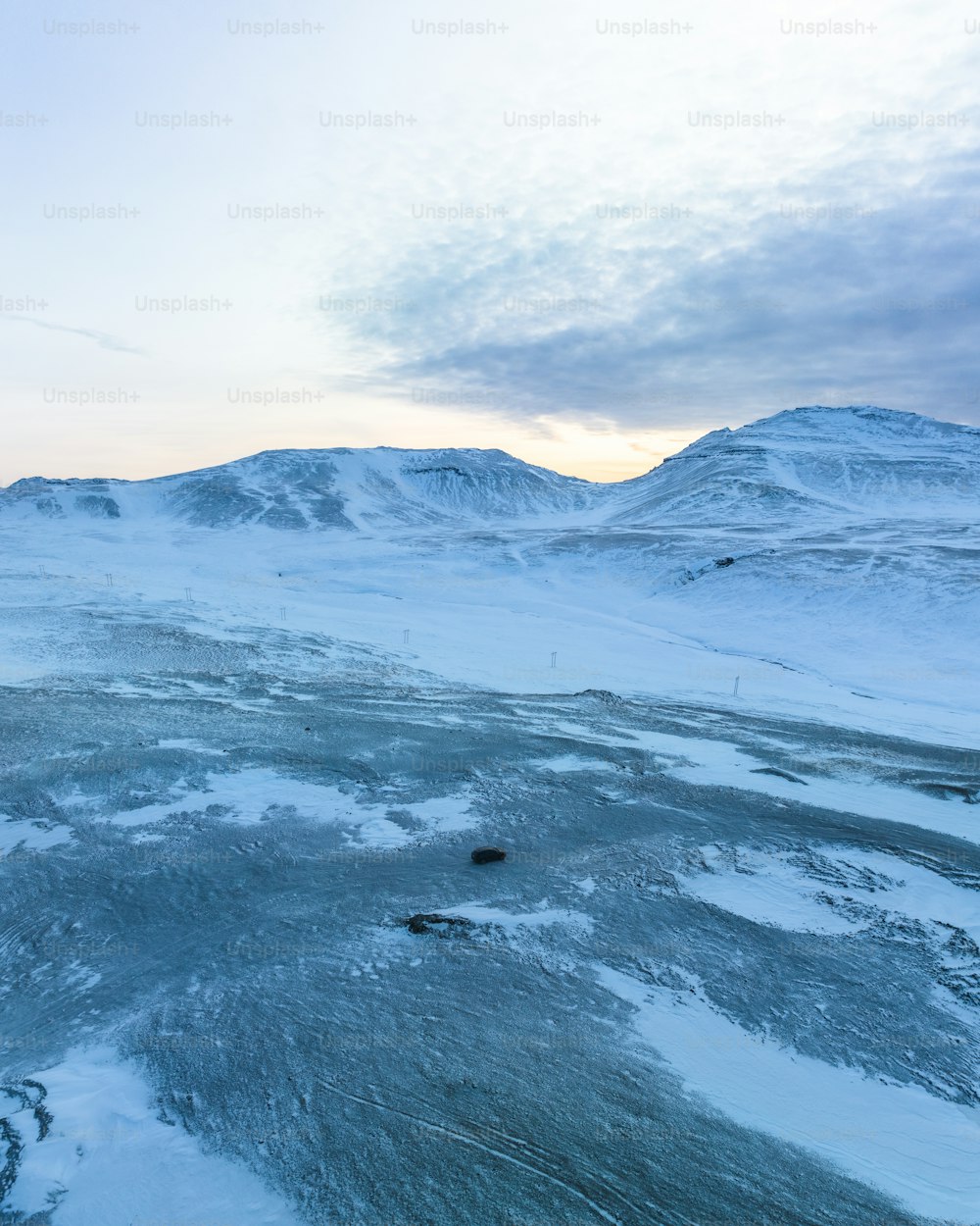 a snow covered landscape with mountains in the background