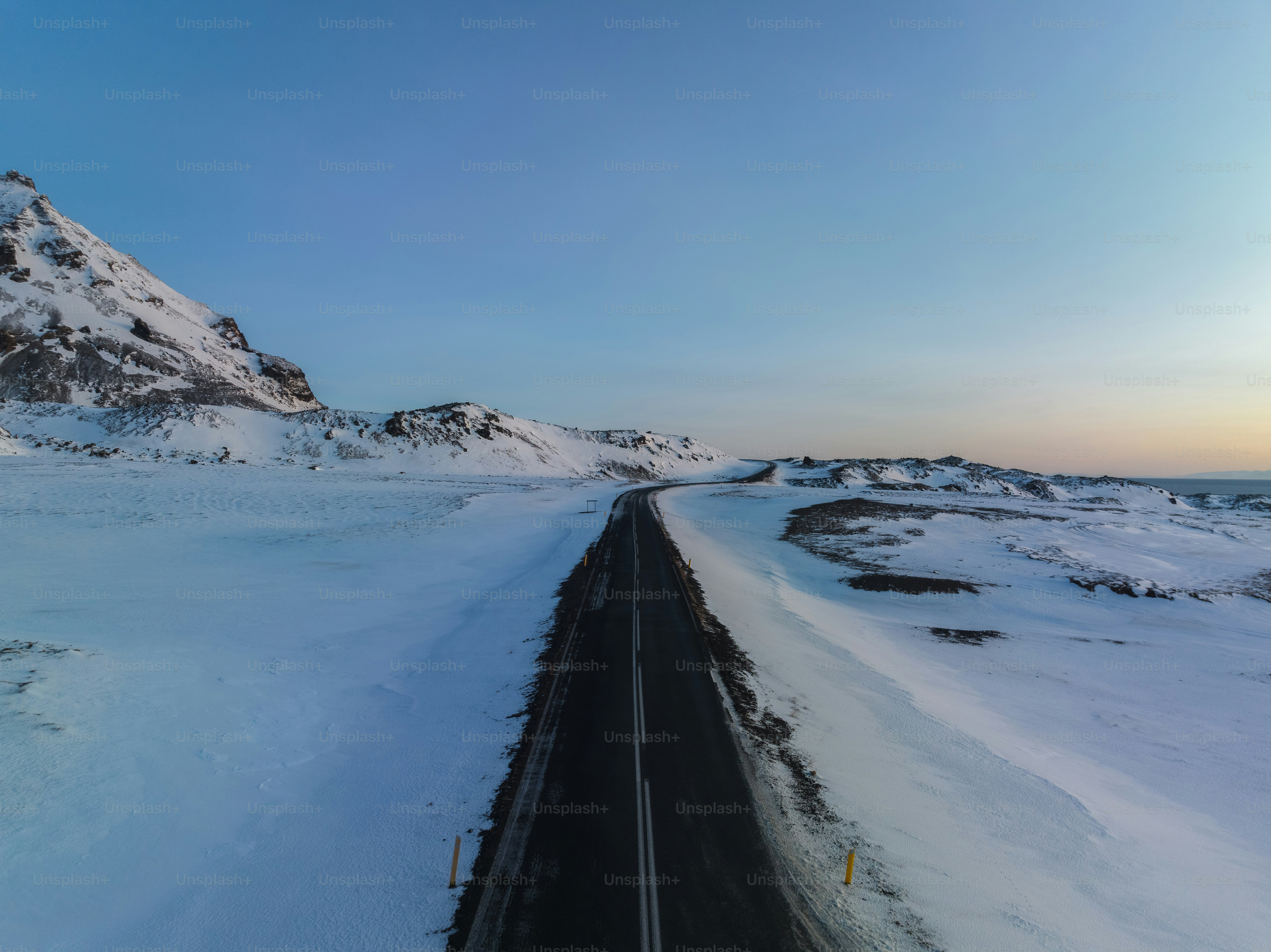 a road in the middle of a snowy field
