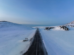 a road in the middle of a snowy field