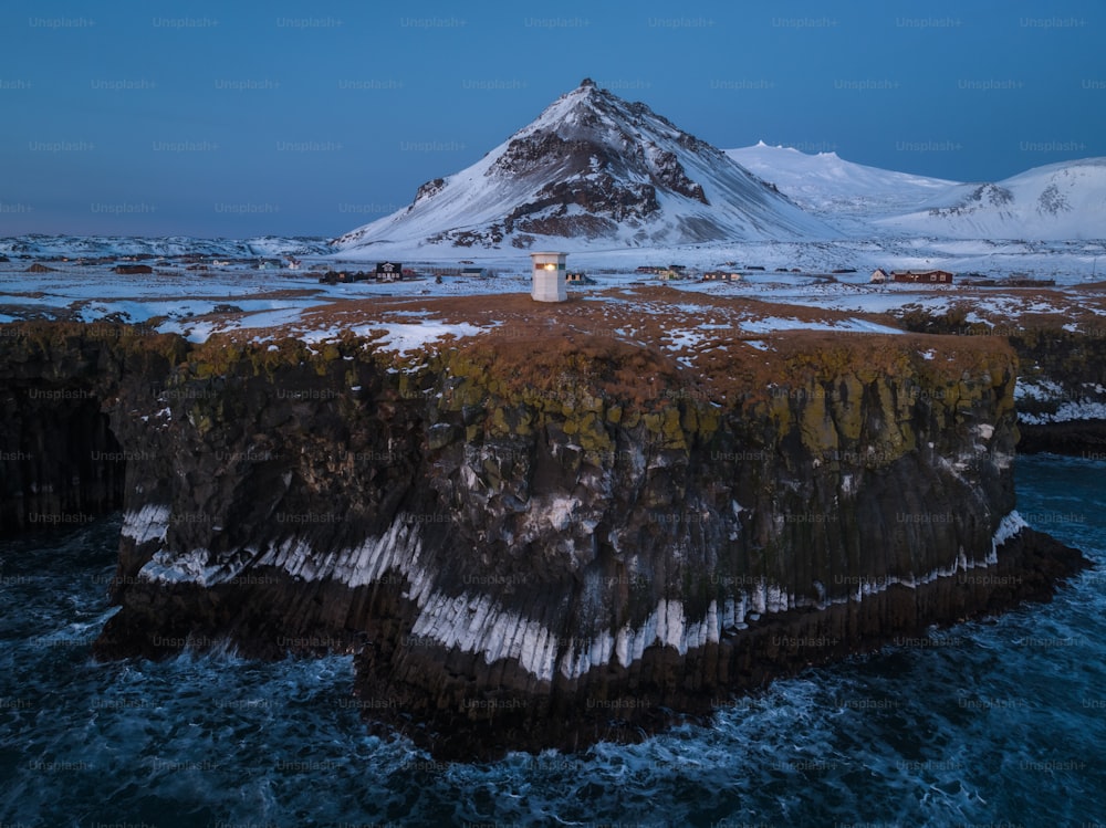 a lighthouse on an island in the middle of the ocean