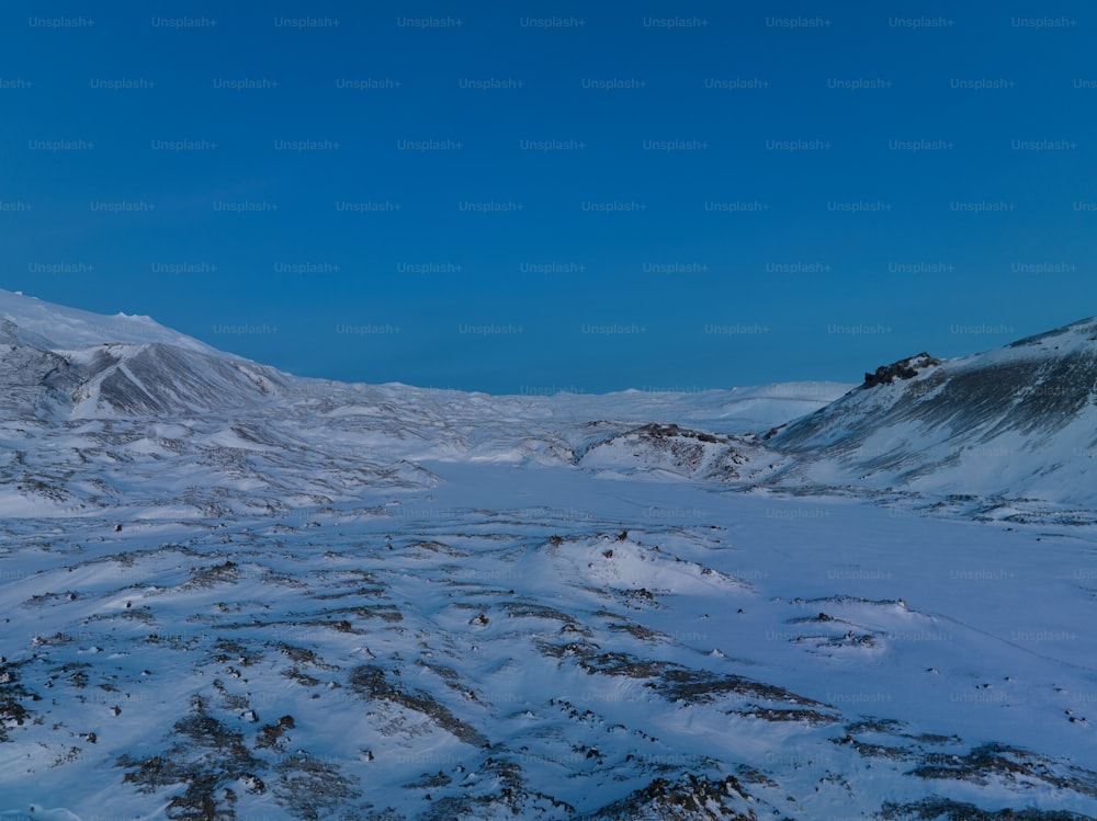 a snow covered mountain range under a blue sky