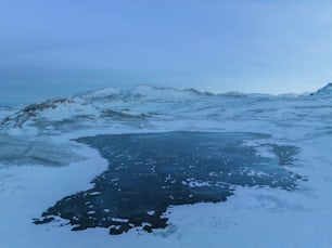 a large body of water surrounded by snow covered mountains