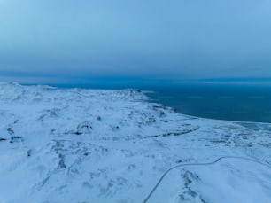 a view of a snow covered mountain and the ocean