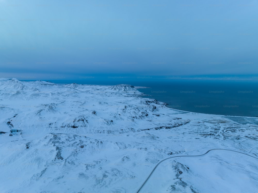 a view of a snow covered mountain and the ocean
