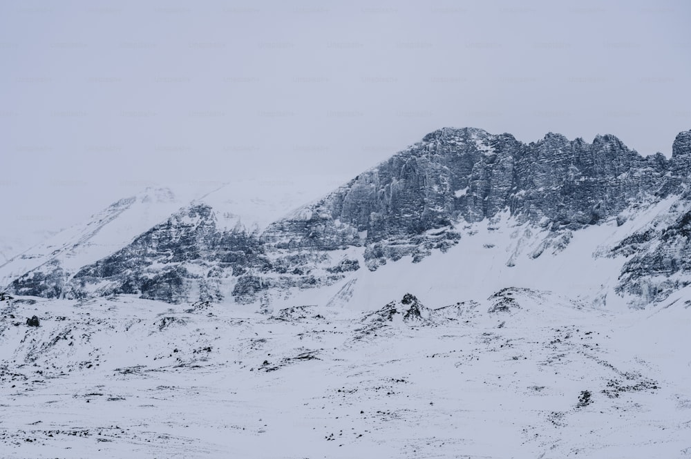 a mountain covered in snow with a sky background