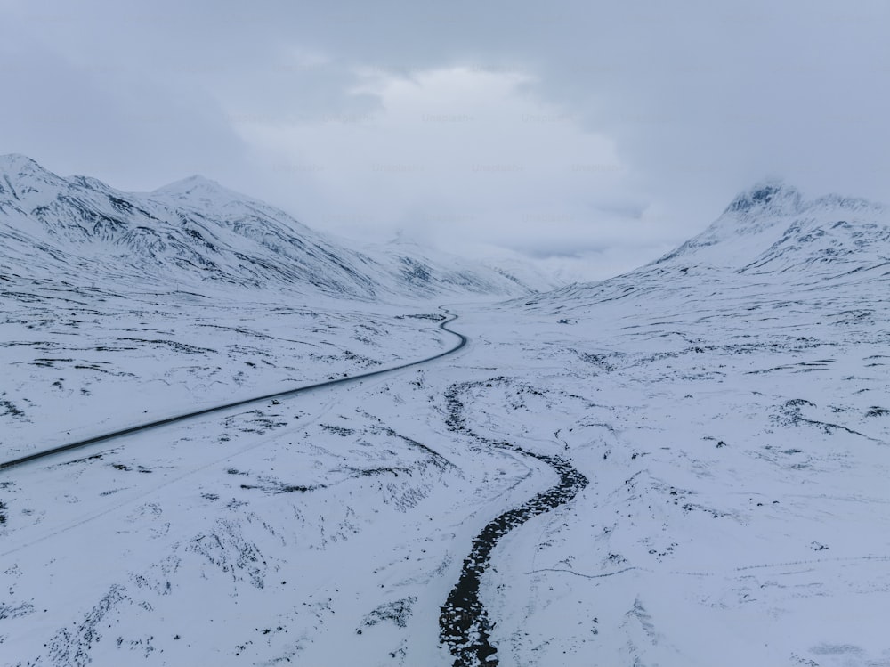 Una montaña nevada con un camino sinuoso en el medio