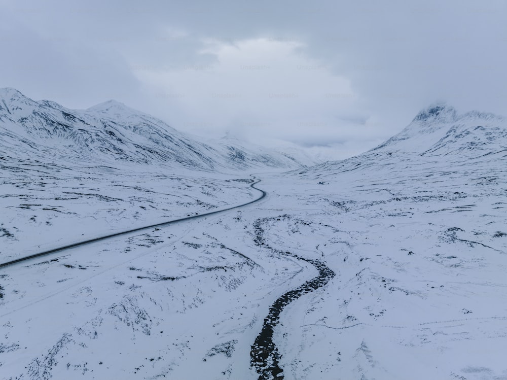 a snowy mountain with a winding road in the middle