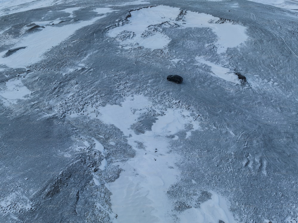 an aerial view of a black object in the snow