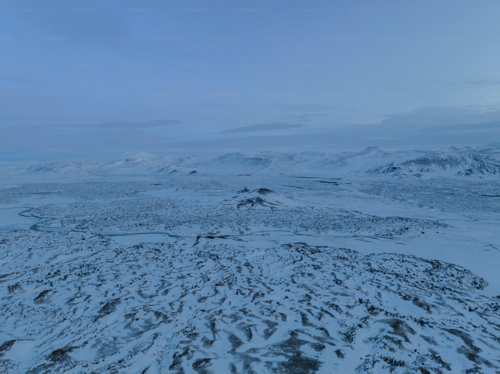 Eine verschneite Landschaft mit Bergen in der Ferne